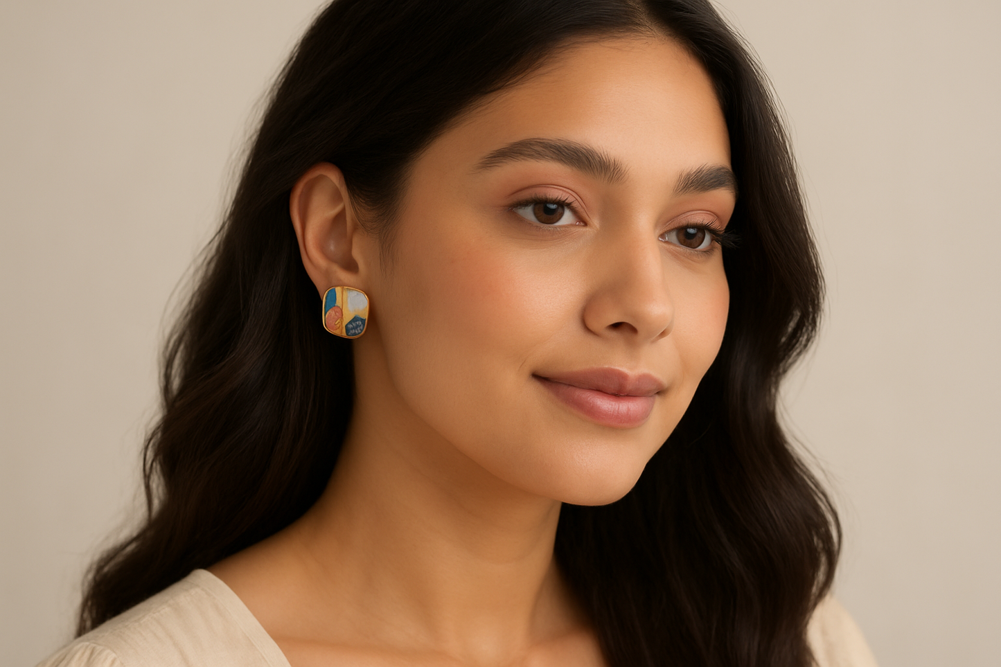 Elegant Indian female model with long wavy hair wearing colorful enamel square stud earrings