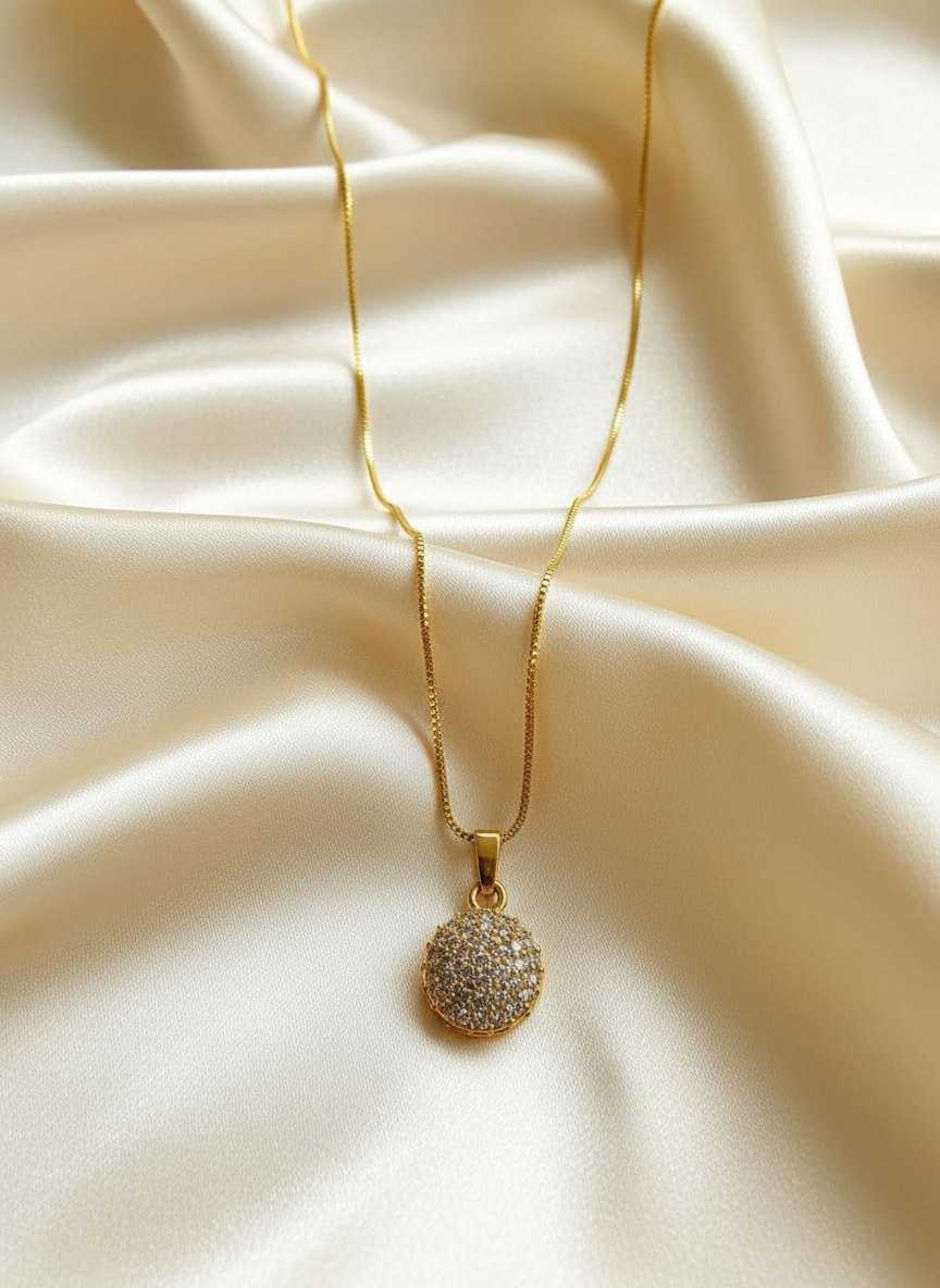Gold necklace with white stone pendant on satin
