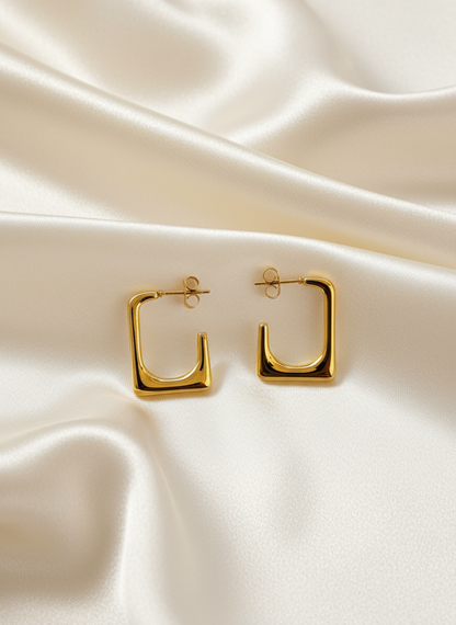 Gold square hoop earrings on ivory satin
