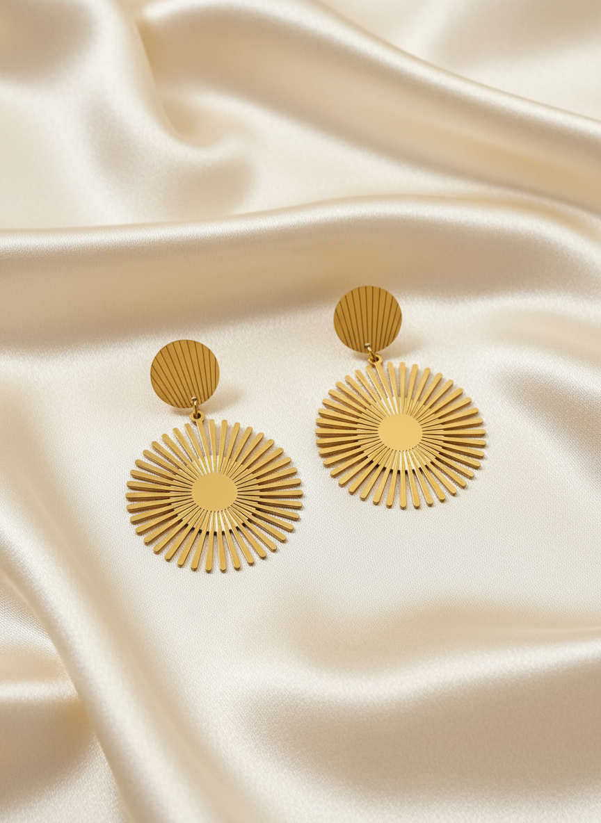 Gold sunburst earrings on satin cloth