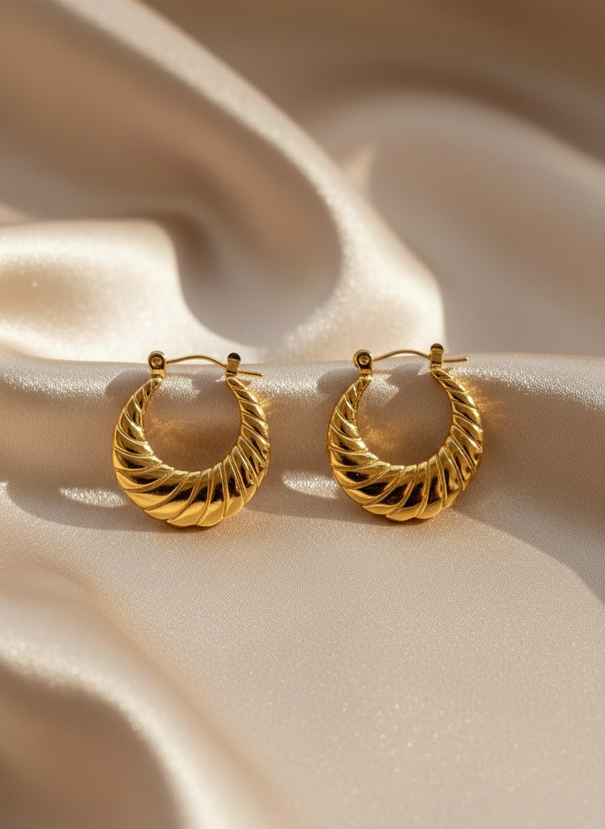 Gold Twisted Hoop Earrings on Beige Satin
